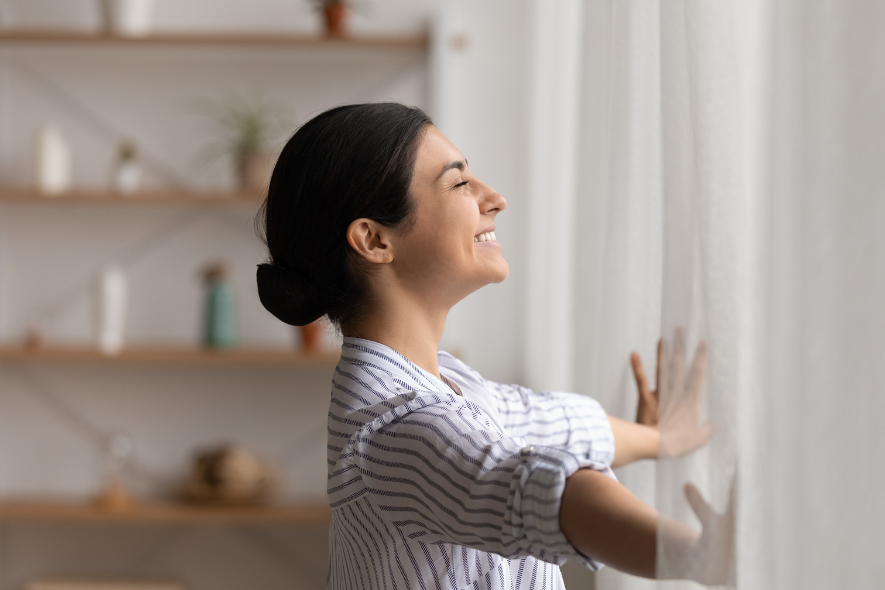 woman opening her curtains